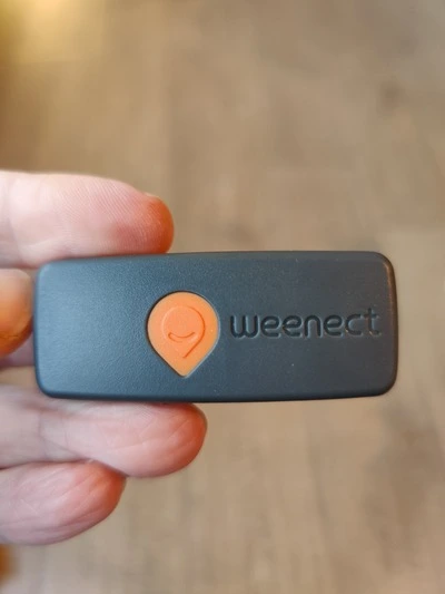 Weenect XS kat tracker close up voorkant in hand (GPSExperts.nl test)