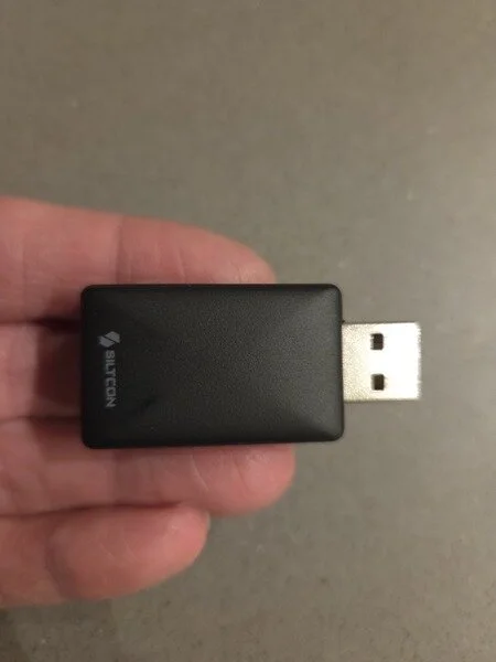 Siltcon carplay dongle vastgehouden in hand op ware grootte (GPSExperts.nl test)